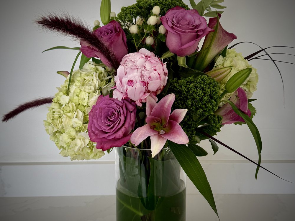 Bloom Rise — a tall, architectural arrangement in a cylinder vessel