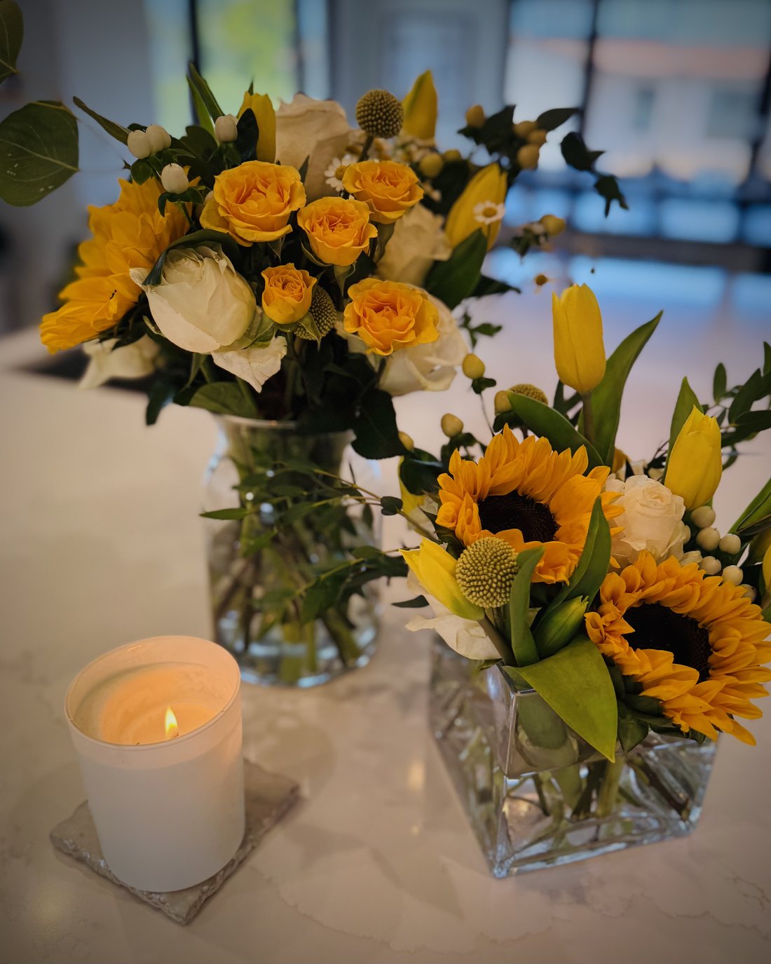 Seasonal Bloom Ritual arrangements styled on a kitchen counter with a candle